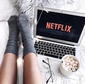 laptop on a bed with Netflix on the screen